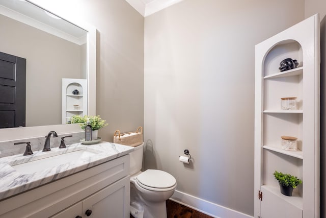 bathroom with built in shelves, baseboards, toilet, wood finished floors, and vanity