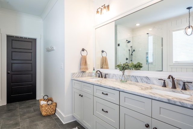 bathroom with double vanity, crown molding, a stall shower, and a sink