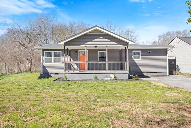 view of front of house with crawl space, covered porch, a front lawn, and a shingled roof