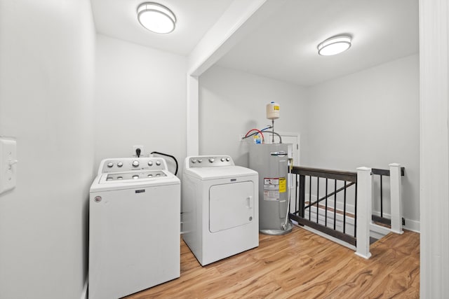 laundry room with water heater, light wood-style floors, and washing machine and clothes dryer