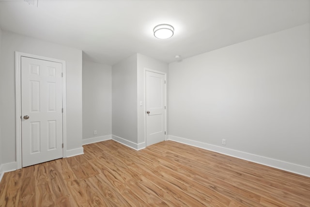 spare room with light wood-type flooring and baseboards