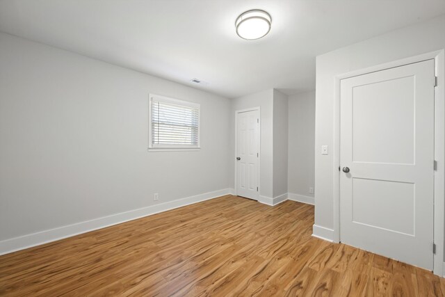 unfurnished bedroom featuring visible vents, light wood-style floors, and baseboards
