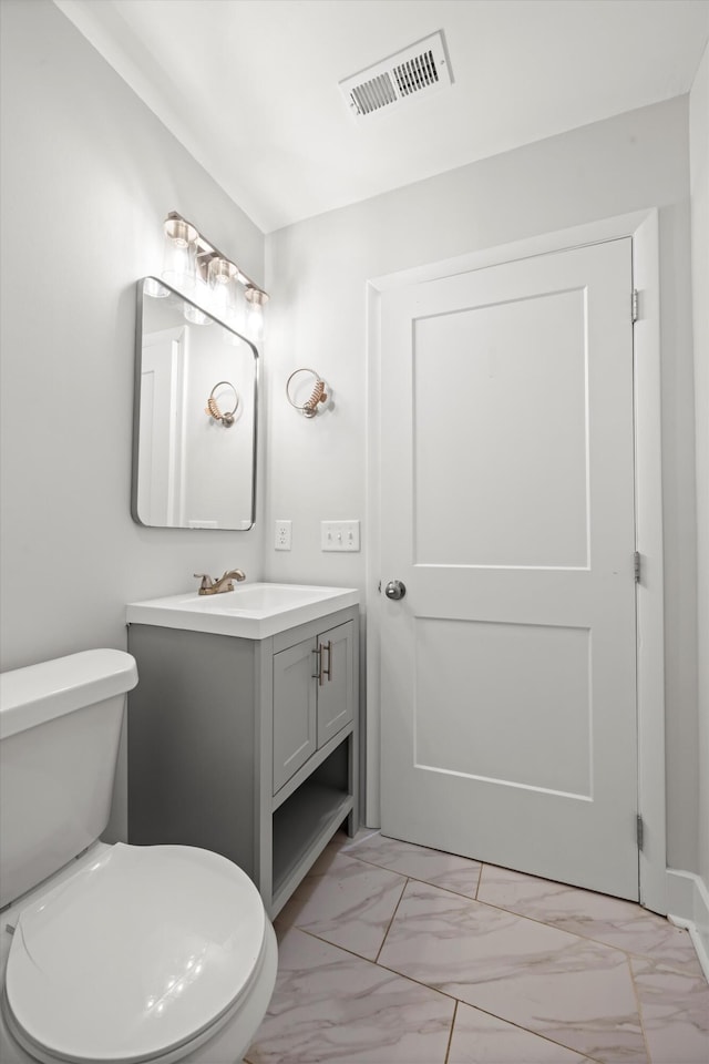 bathroom featuring visible vents, toilet, marble finish floor, and vanity