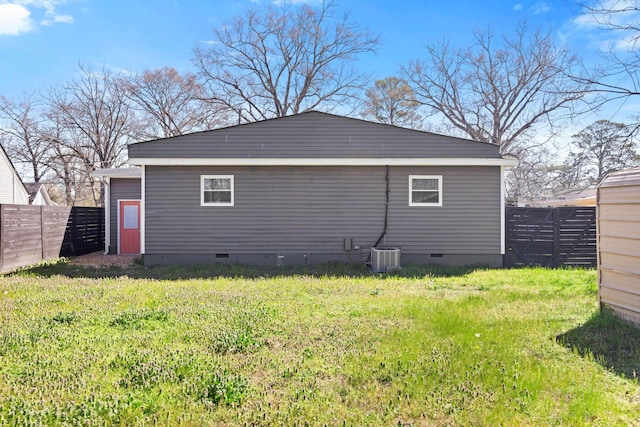 back of house featuring crawl space, a yard, and fence