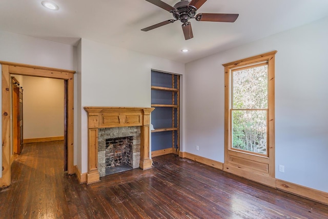 209 Tremont St, Chattanooga, TN 37405 - unfurnished living room featuring a stone fireplace, dark wood-style floors, baseboards, and a ceiling fan