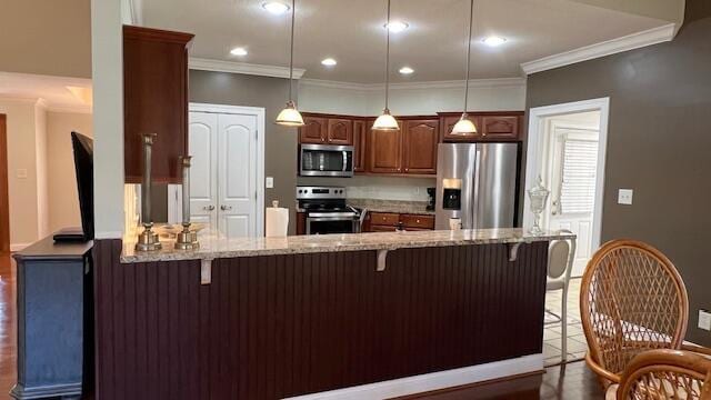 kitchen with light stone countertops, a peninsula, a kitchen breakfast bar, crown molding, and stainless steel appliances