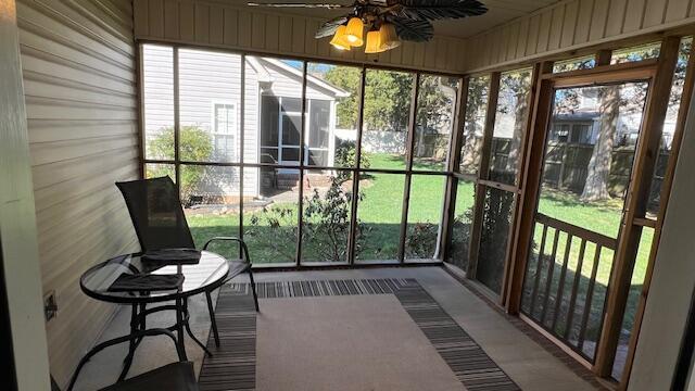 sunroom / solarium featuring a healthy amount of sunlight and ceiling fan