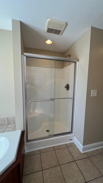 full bath featuring a stall shower, tile patterned flooring, visible vents, and a textured ceiling