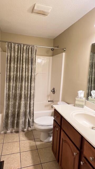 bathroom with shower / bath combo with shower curtain, toilet, tile patterned flooring, and vanity