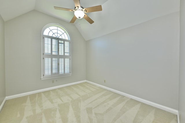 carpeted spare room with ceiling fan, baseboards, and lofted ceiling