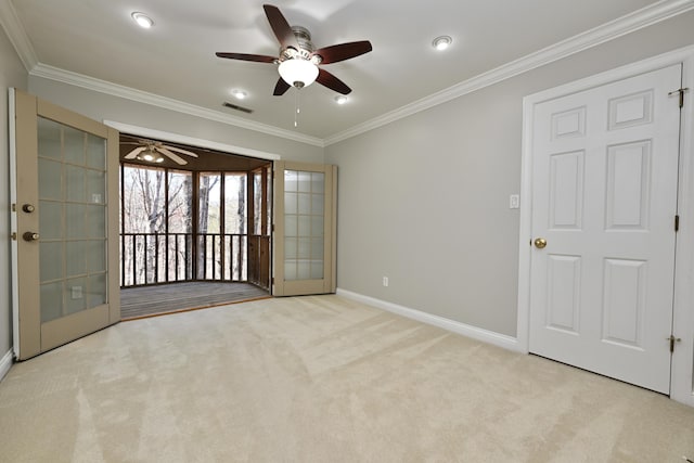 carpeted empty room featuring ornamental molding, baseboards, a ceiling fan, and visible vents