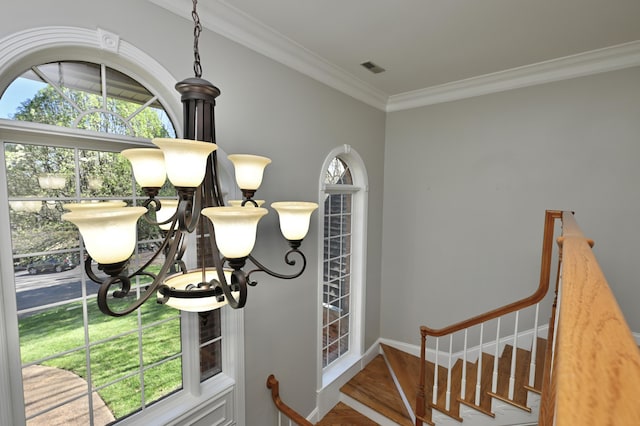 foyer entrance with visible vents, baseboards, ornamental molding, and wood finished floors