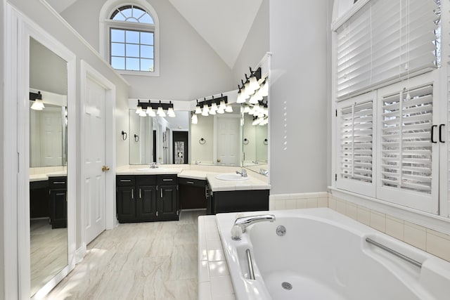 full bathroom featuring a garden tub, high vaulted ceiling, and vanity