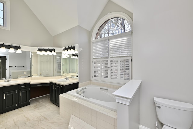 bathroom with toilet, high vaulted ceiling, vanity, and a garden tub