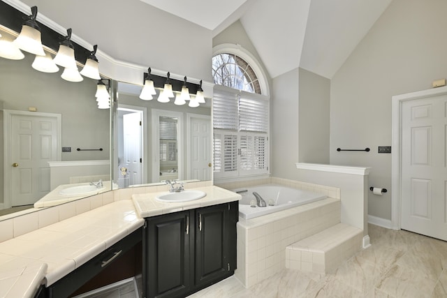 bathroom featuring a sink, double vanity, high vaulted ceiling, marble finish floor, and a garden tub
