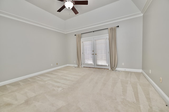 spare room with light colored carpet, baseboards, crown molding, and ceiling fan