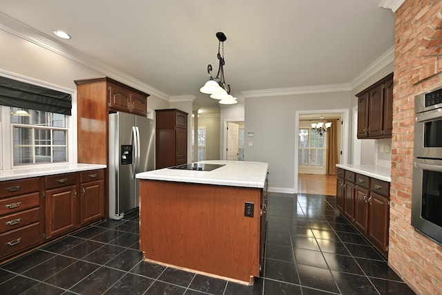 kitchen with dark tile patterned flooring, ornamental molding, a center island, and stainless steel appliances
