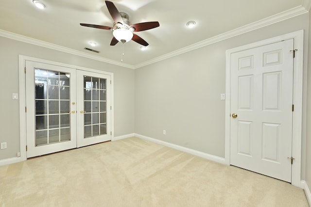 empty room with visible vents, a ceiling fan, crown molding, french doors, and light colored carpet