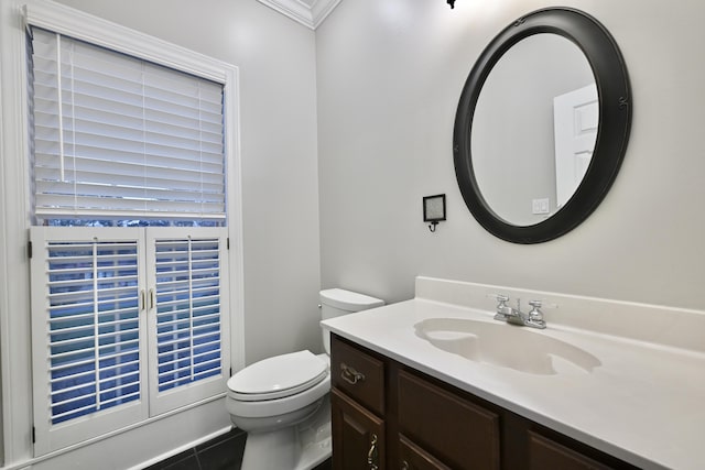 bathroom featuring tile patterned floors, vanity, ornamental molding, and toilet