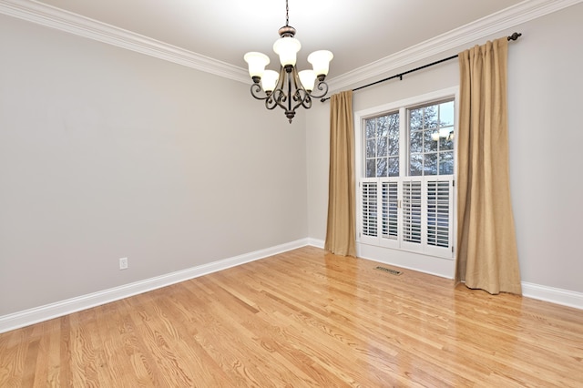 spare room with baseboards, ornamental molding, a chandelier, visible vents, and light wood finished floors