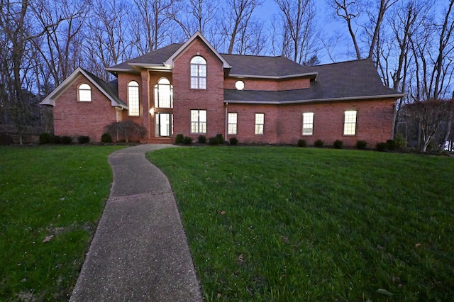 view of front of house with brick siding and a front lawn