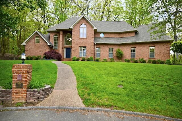 traditional-style house with brick siding and a front lawn