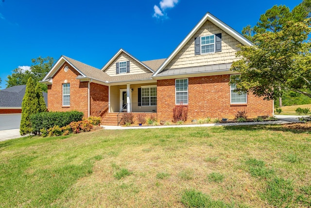 view of front of property with a front lawn, covered porch, and brick siding