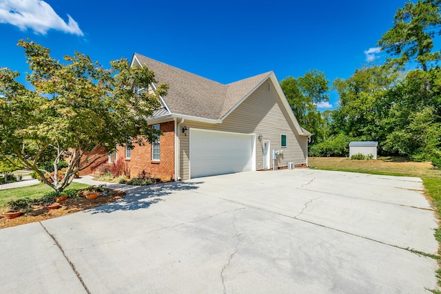 view of side of property with driveway, brick siding, roof with shingles, and an attached garage