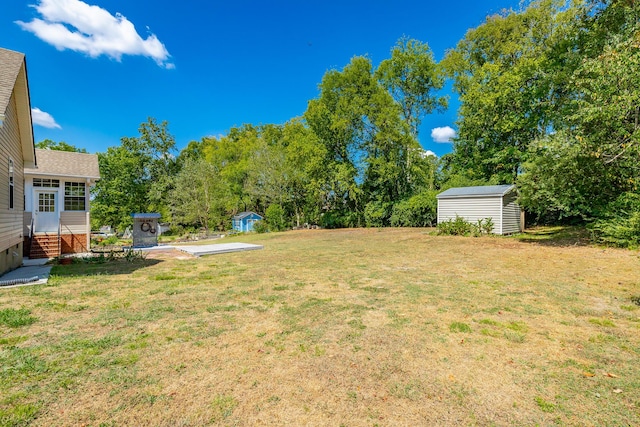 view of yard with a storage unit, an outbuilding, and entry steps
