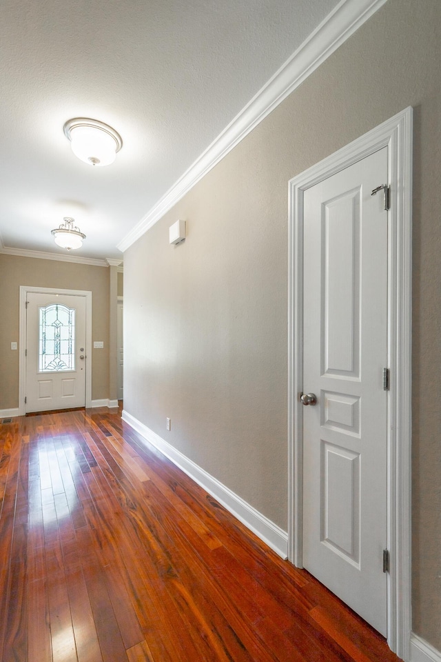 interior space with crown molding, baseboards, and wood-type flooring