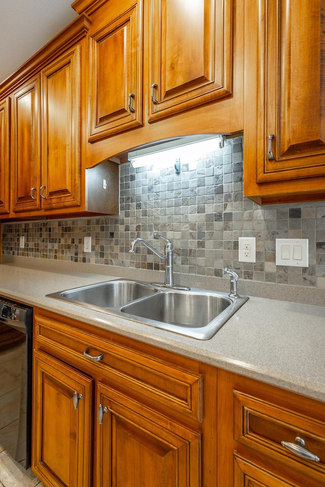 kitchen featuring brown cabinetry, a sink, light countertops, black dishwasher, and tasteful backsplash