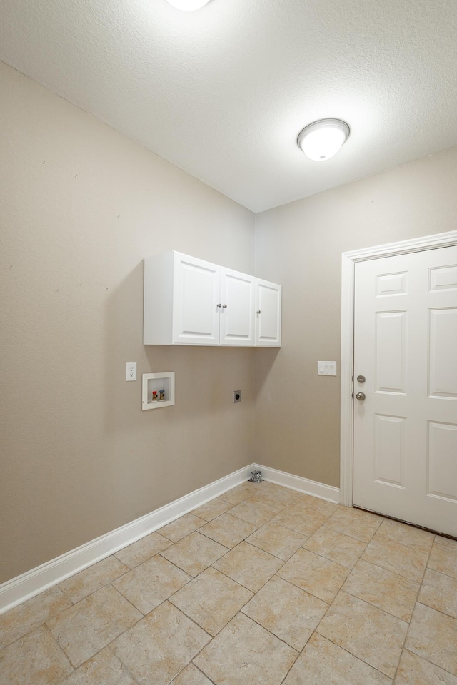 laundry room featuring baseboards, hookup for a washing machine, cabinet space, electric dryer hookup, and a textured ceiling