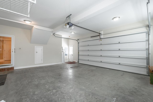 garage featuring a garage door opener and baseboards