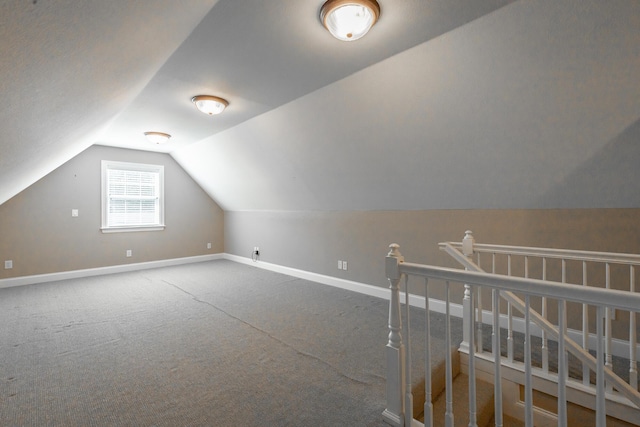 bonus room with lofted ceiling, carpet flooring, and baseboards