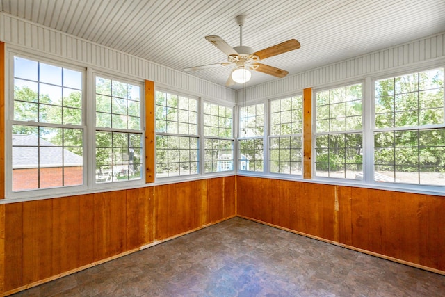 unfurnished sunroom with tile patterned floors and wood walls