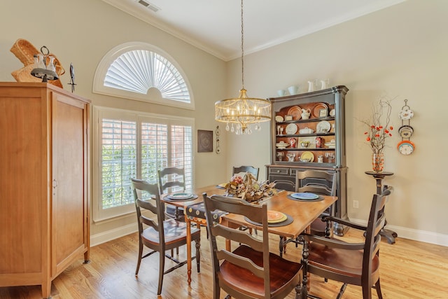 dining room with visible vents, ornamental molding, an inviting chandelier, light wood-style floors, and baseboards