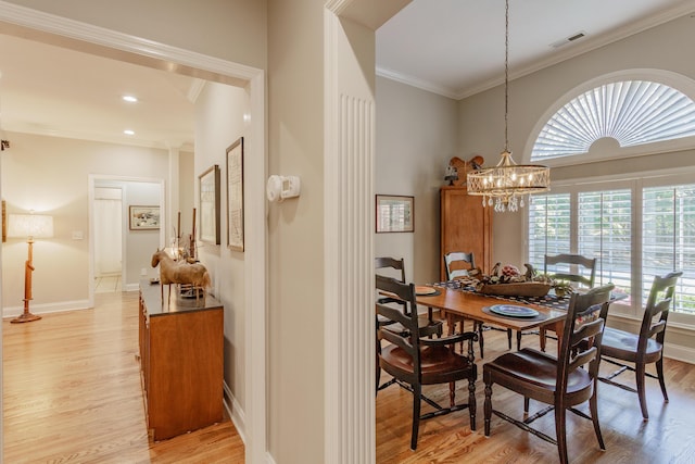 dining room with visible vents, light wood-style floors, crown molding, and a chandelier