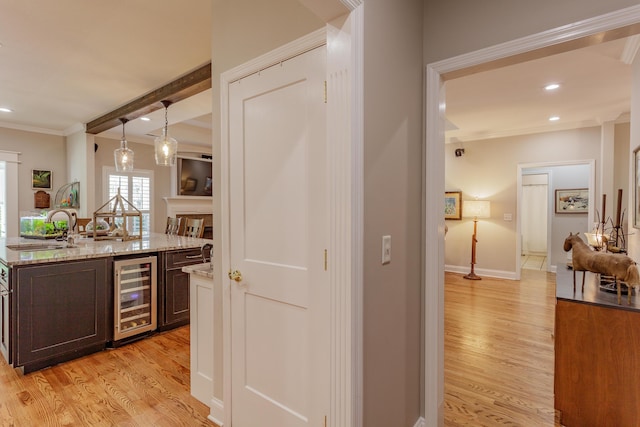 bar featuring crown molding, wine cooler, recessed lighting, a sink, and light wood finished floors