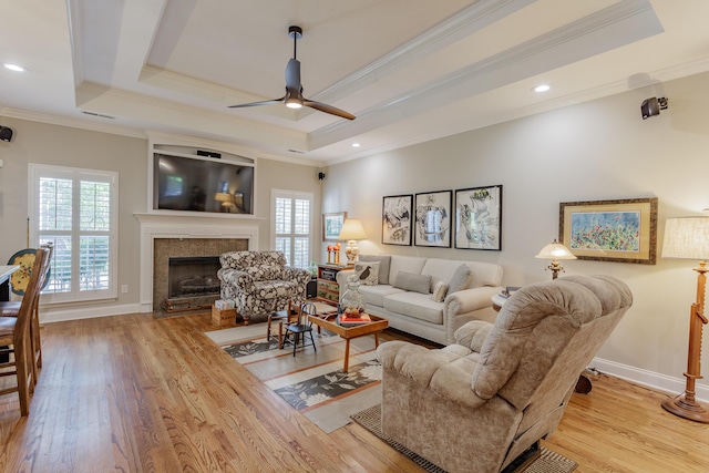 living room with a healthy amount of sunlight, ceiling fan, light wood-type flooring, and crown molding