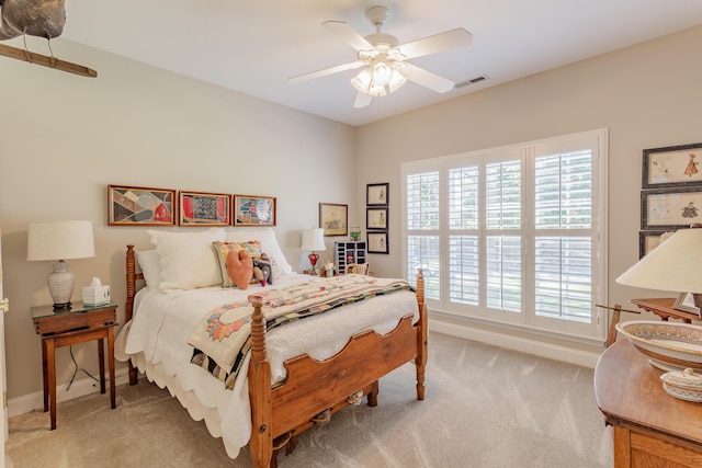 bedroom featuring visible vents, a ceiling fan, baseboards, and light carpet