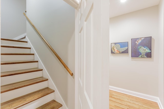 stairs with baseboards and wood finished floors