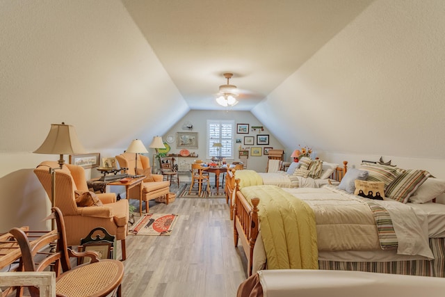 bedroom featuring a ceiling fan, light wood-style flooring, and lofted ceiling