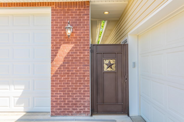 property entrance with brick siding and a garage