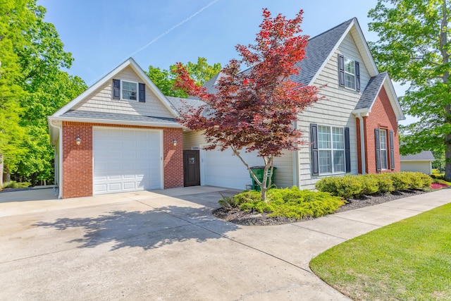 view of front of house featuring brick siding, a garage, a shingled roof, and concrete driveway