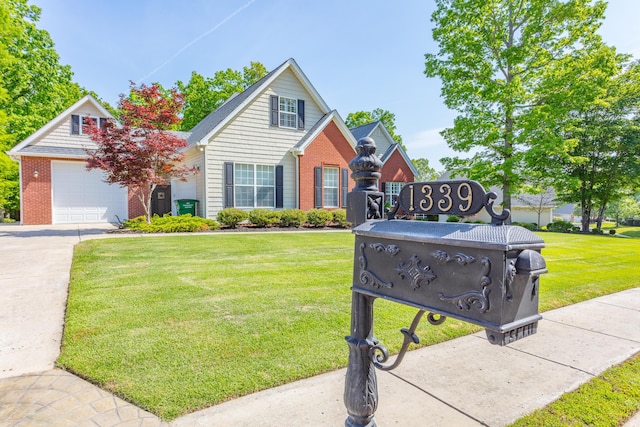 view of front of home with brick siding, a front lawn, and driveway