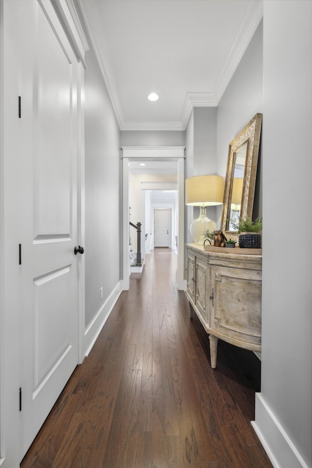 corridor with crown molding, recessed lighting, baseboards, and dark wood-style flooring