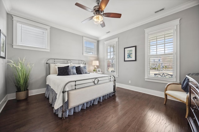 bedroom with dark wood-style floors, visible vents, crown molding, and baseboards