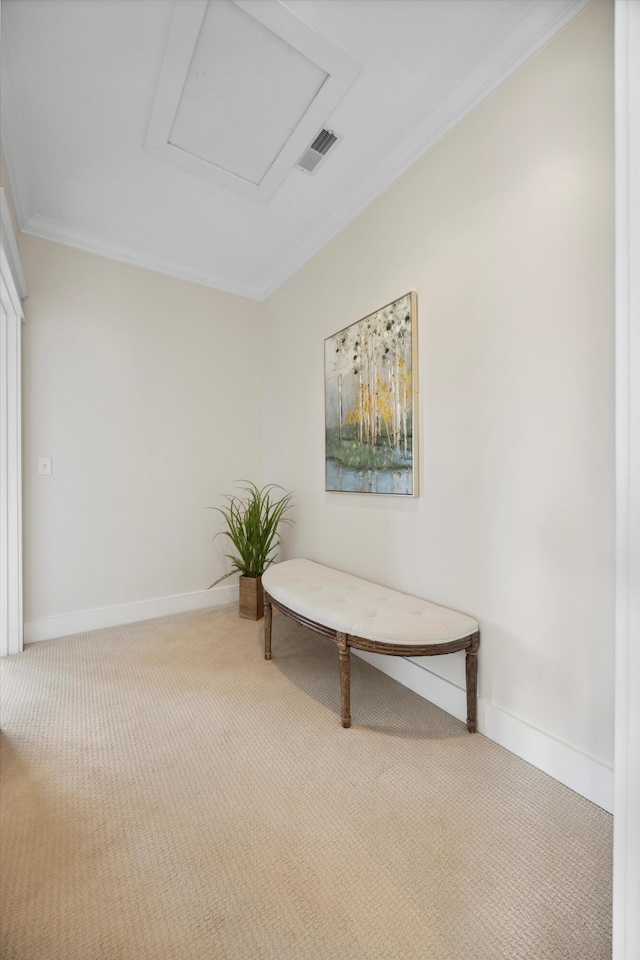 living area featuring baseboards, attic access, carpet, and ornamental molding