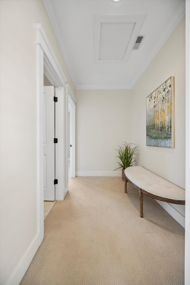 hall with visible vents, baseboards, light colored carpet, and ornamental molding