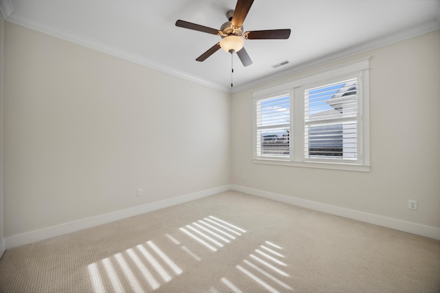empty room with light colored carpet, crown molding, baseboards, and visible vents